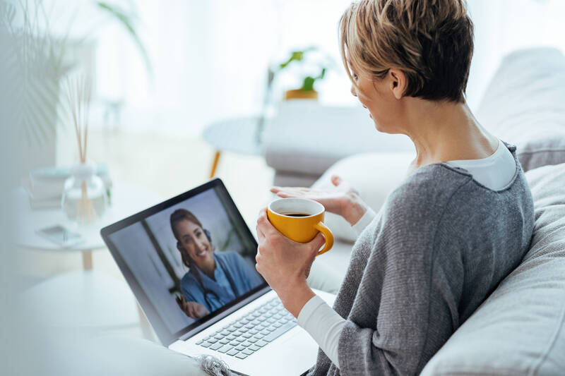 Mit dem Laptop auf dem Schoß kann man die Online Konsultation bequem von Zuhause aus tätigen